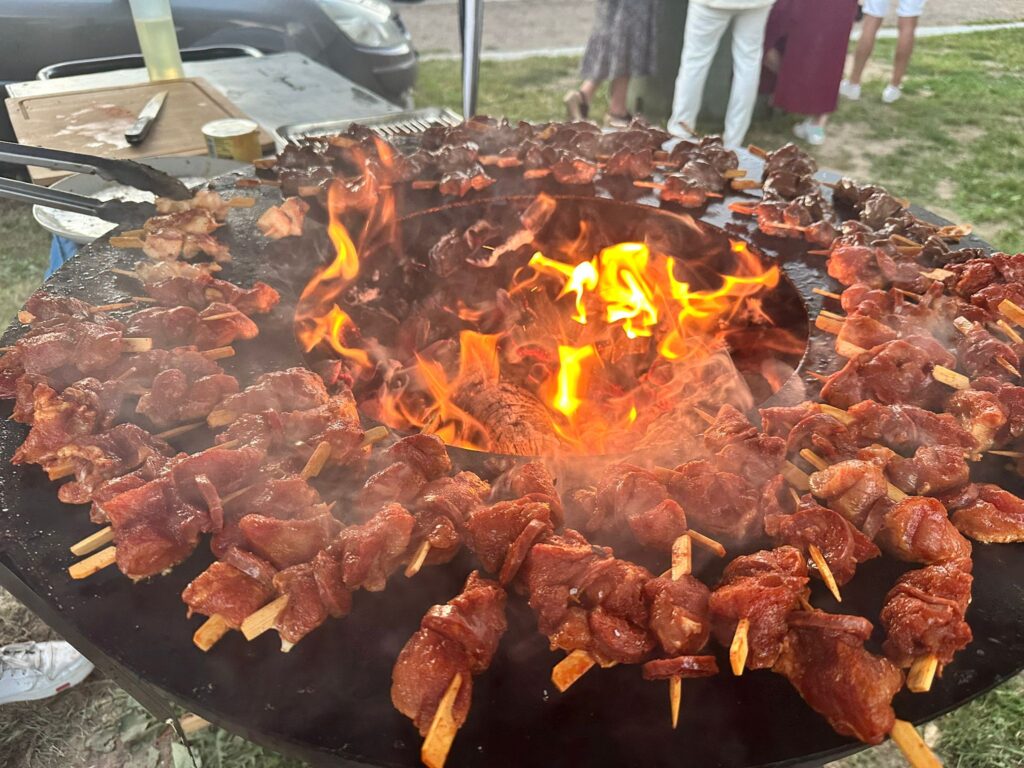 Brochettes de viande grillées autour d'un feu circulaire en extérieur