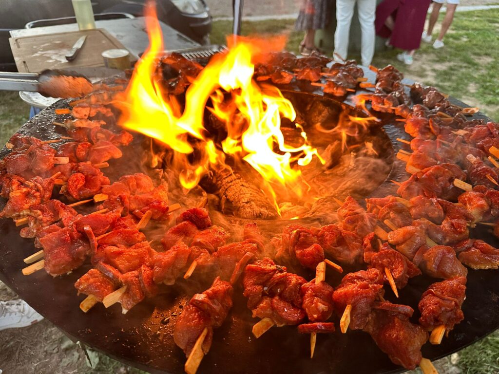 Brochettes de viande grillant sur un feu vif lors d'un barbecue en plein air