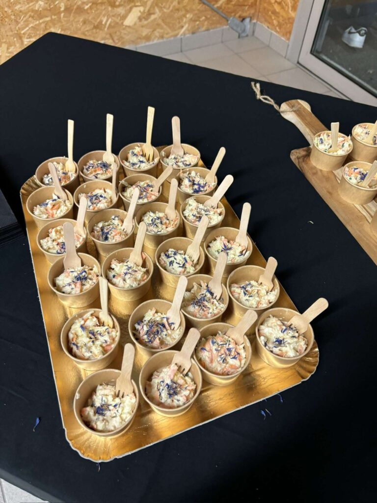 Petites coupelles de salade avec fleurs comestibles présentées sur plateau doré