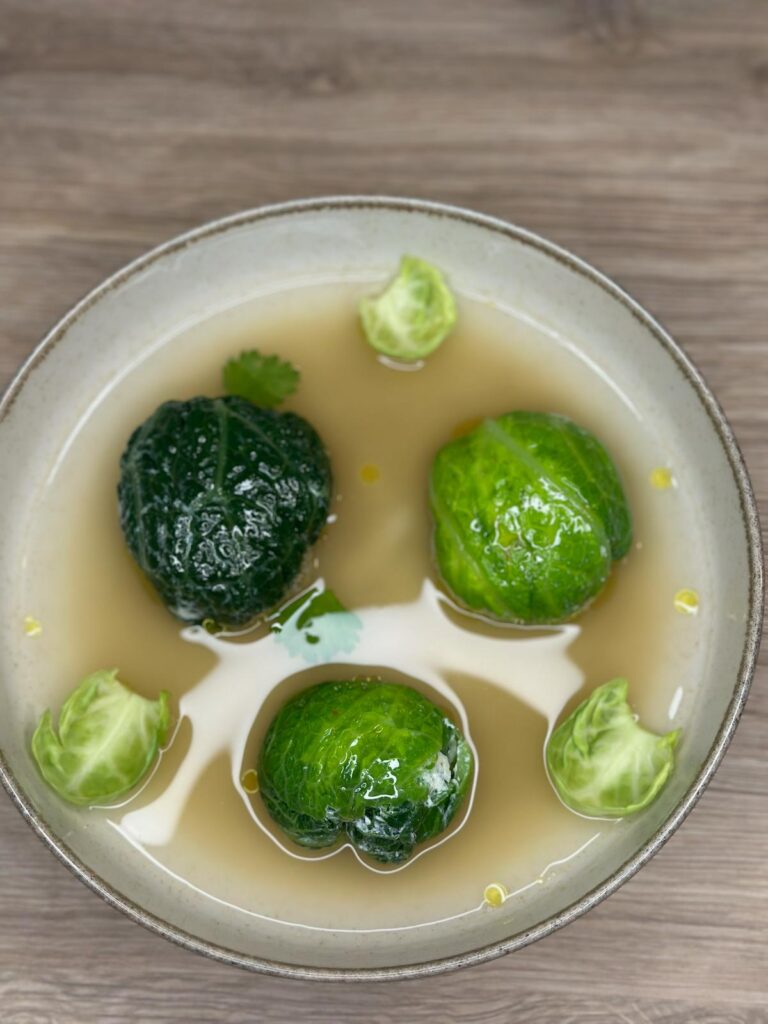 Bouillon clair avec boulettes en feuilles de chou dans une assiette creuse