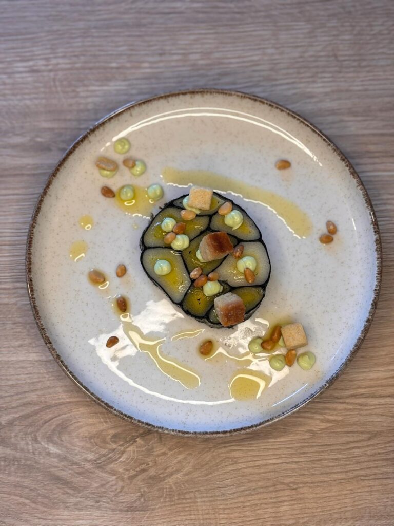 Plat gastronomique avec légumes en gelée, crème, pignons et croûtons délicatement dressé