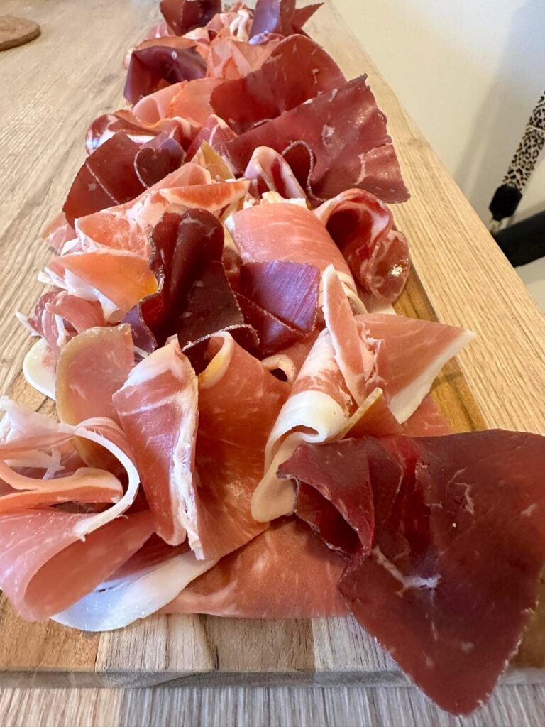 Plateau en bois avec assortiment de charcuterie fine pour apéritif