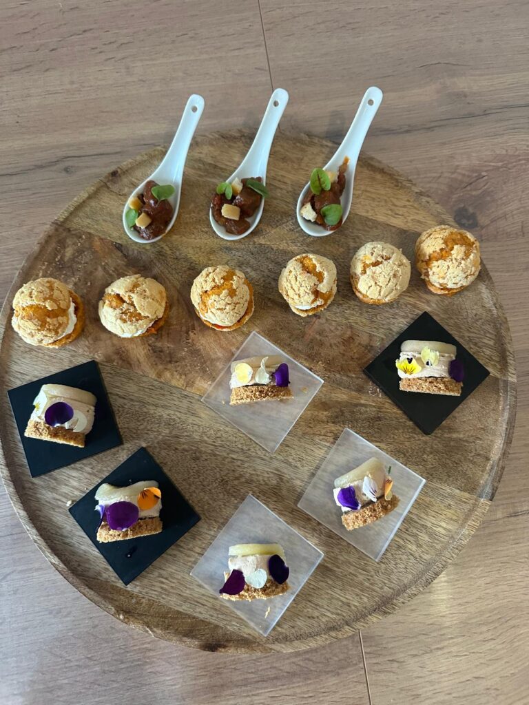 Plateau bois avec bouchées gourmandes et amuse-bouches décorés de fleurs comestibles