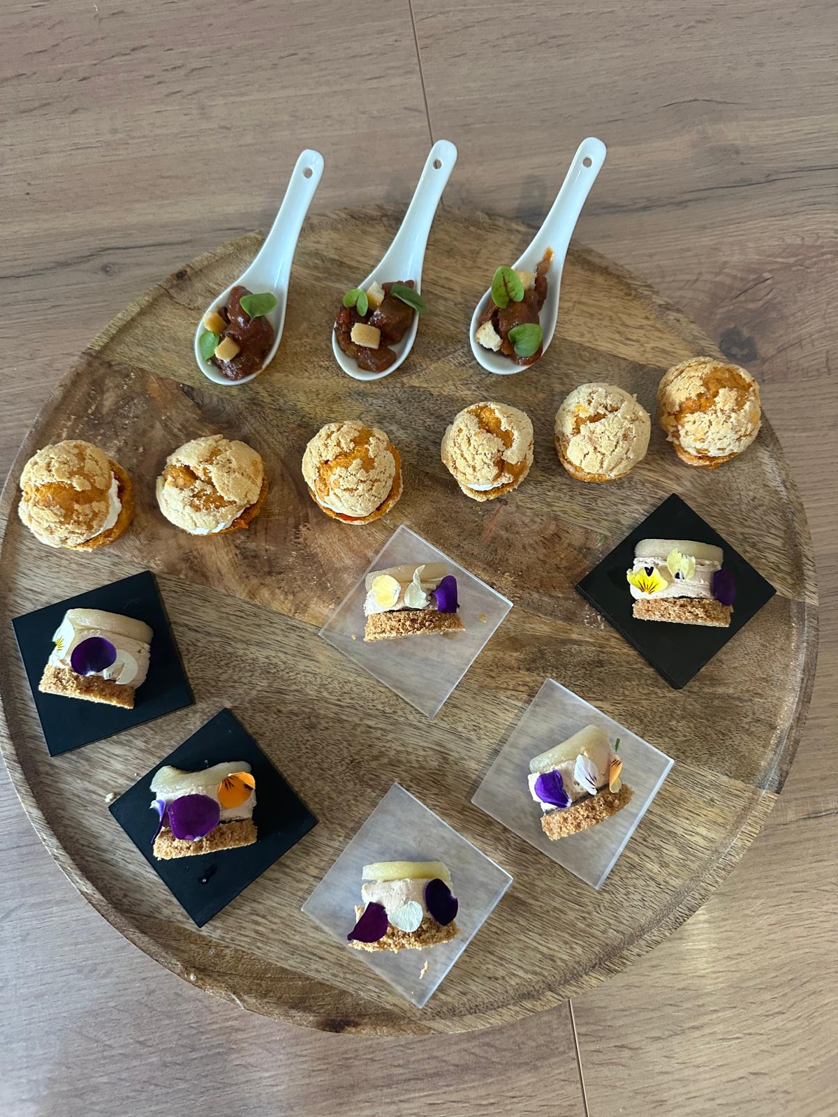 Plateau bois avec bouchées gourmandes et amuse-bouches décorés de fleurs comestibles