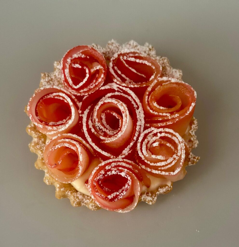 Tartelette aux roses de fruits finement décorée de sucre glace